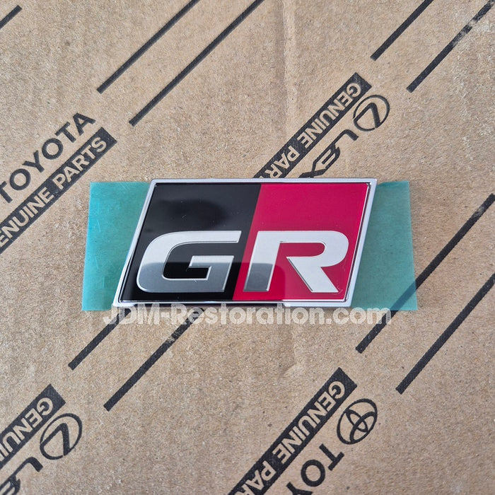 GR Badge on a cardboard background with Toyota branding