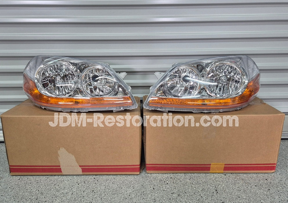 Two car headlights on cardboard boxes with 'JDM-Restoration.com' branding.