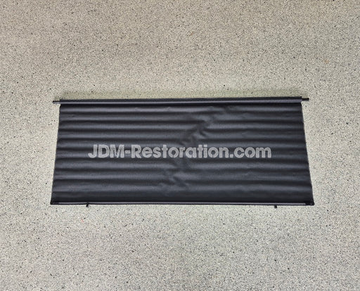 Black car cover with 'JDM-Restoration.com' text on a concrete surface