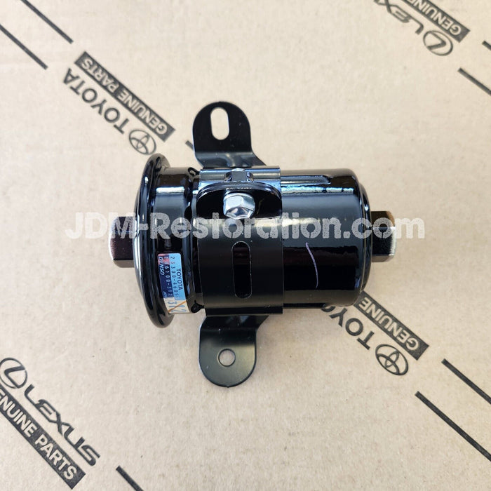 A black Toyota Jzx100 1JZ fuel filter against a cardboard background with 'JDM Restoration' text.