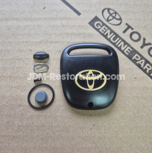 Black car key fob cover with Toyota logo on a cardboard background with Toyota branding.