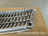 Metal car grille on a cardboard box with 'JDM-Restoration.com' branding.