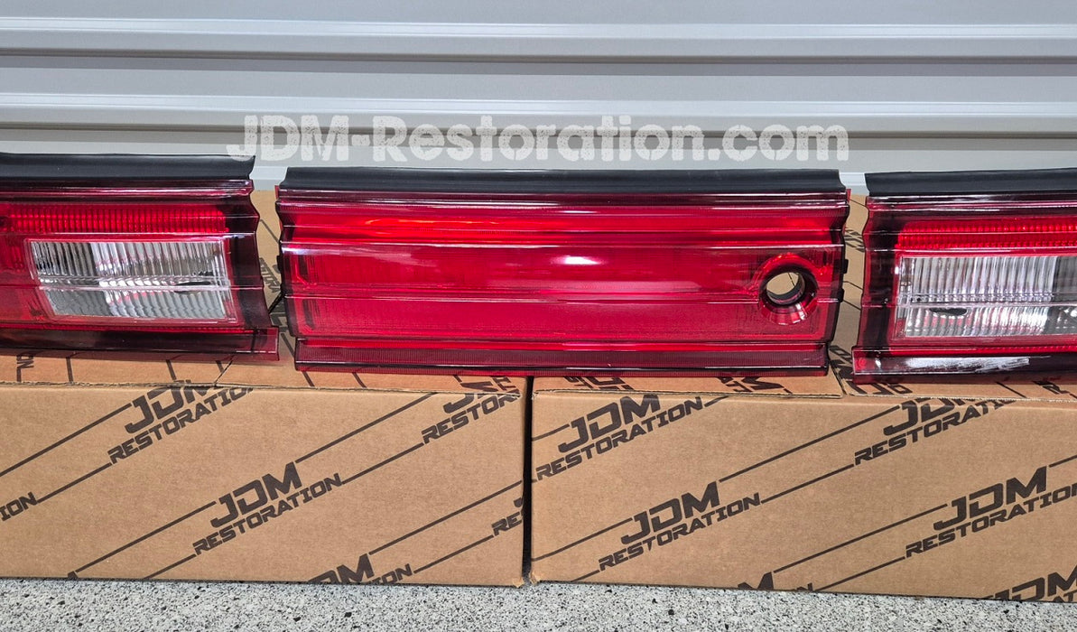 Red car tail lights on cardboard boxes with 'JDM Restoration' branding.