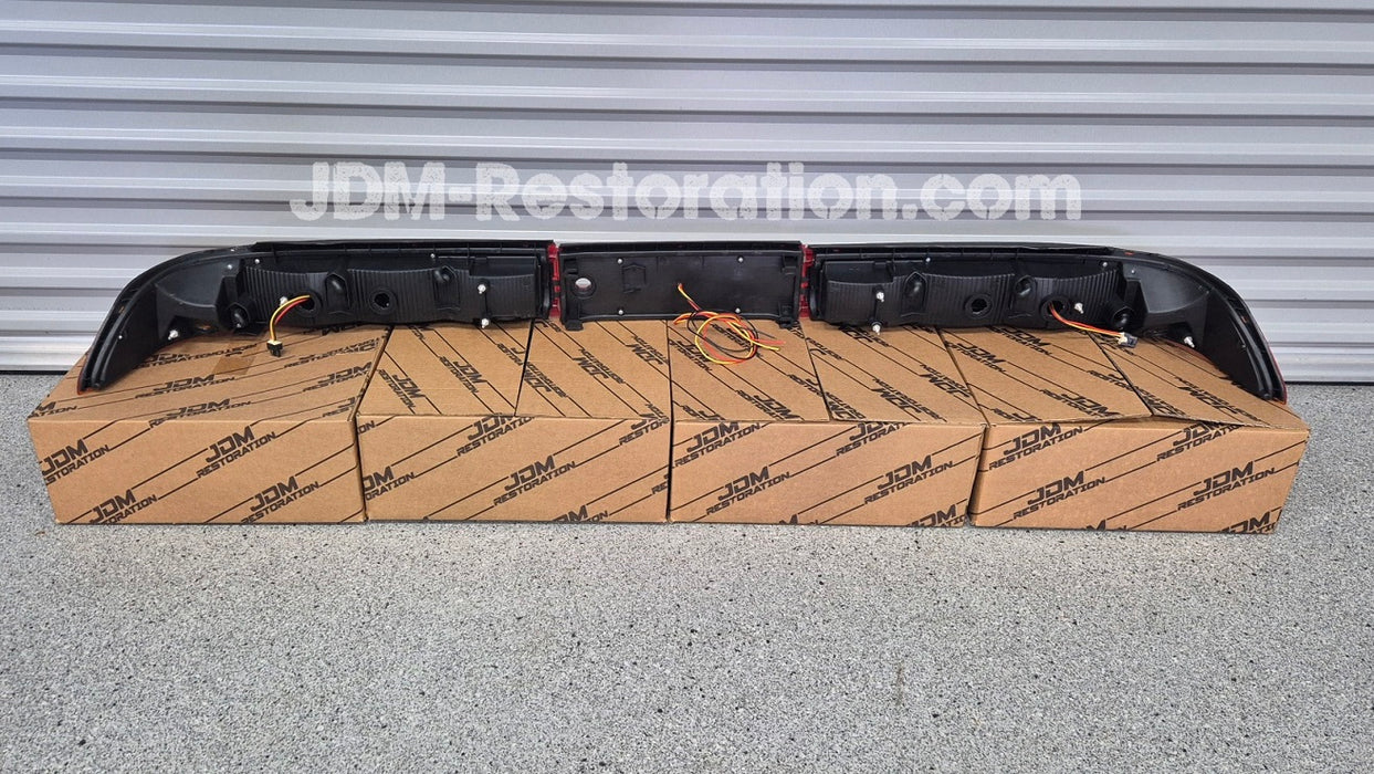 Car tail light assembly on a cardboard box with 'JDM Restoration' branding.