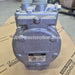 A Denso hydraulic pump with a metallic gray cast body, resting on a cardboard box with Lexus and Toyota branding visible in the background. A JDM Restoration.