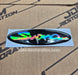 An oval holographic vinyl decal featuring the word 'Supra' in a stylized script, shown on its light blue backing sheet against a cardboard background with JDM Restoration branding.